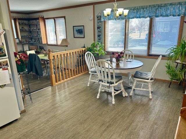 dining room with a chandelier, wood finished floors, and baseboards