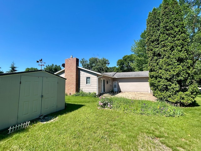 1006 10th St SW, Wadena, MN 56482 - rear view of house with a storage unit, a lawn, and a chimney