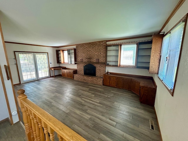 1006 10th St SW, Wadena, MN 56482 - unfurnished living room featuring crown molding, wood finished floors, and a brick fireplace