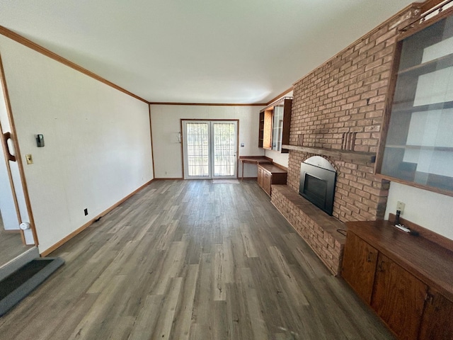 1006 10th St SW, Wadena, MN 56482 - unfurnished living room with a fireplace, dark wood-type flooring, and crown molding