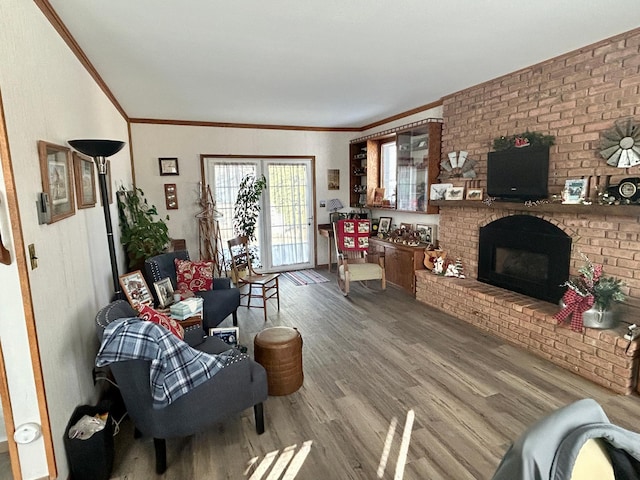 1006 10th St SW, Wadena, MN 56482 - living room featuring wood finished floors, crown molding, and a brick fireplace
