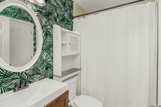 bathroom featuring toilet, vanity, and wallpapered walls