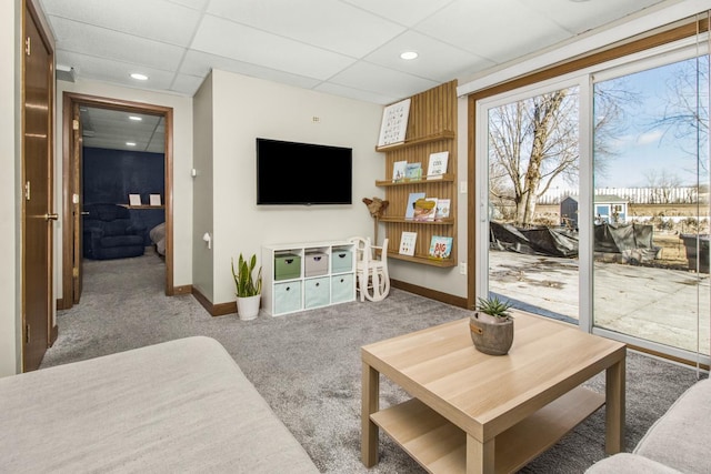 carpeted living area with recessed lighting, baseboards, and a drop ceiling