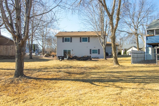 rear view of property with a yard and fence