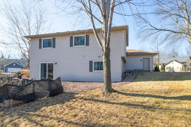 rear view of house featuring a lawn