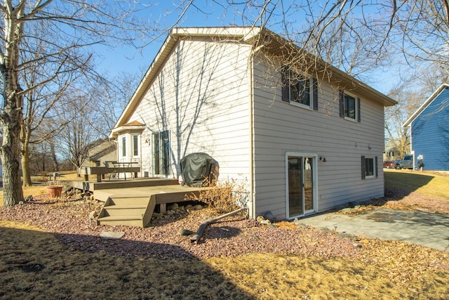 back of property featuring a patio and a deck