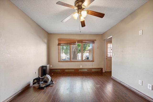 empty room featuring a textured ceiling, ceiling fan, hardwood / wood-style floors, and baseboards