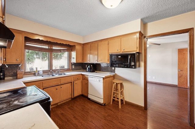 kitchen with dark wood-style floors, light countertops, a sink, under cabinet range hood, and black appliances