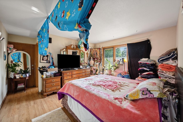 bedroom with wood finished floors and access to exterior