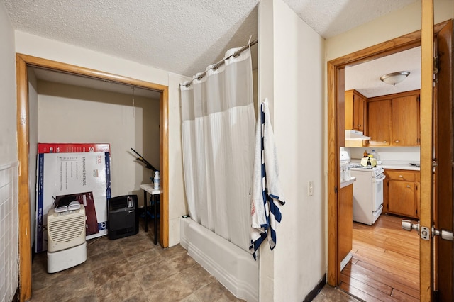 full bathroom featuring a textured ceiling, wood finished floors, shower / bath combination with curtain, and vanity