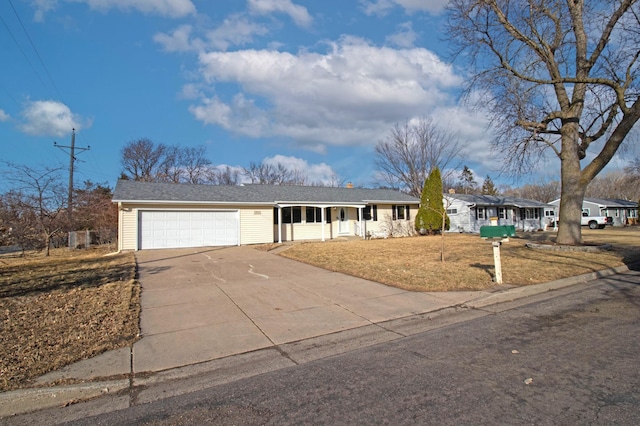 ranch-style home with an attached garage, a porch, a front lawn, and concrete driveway