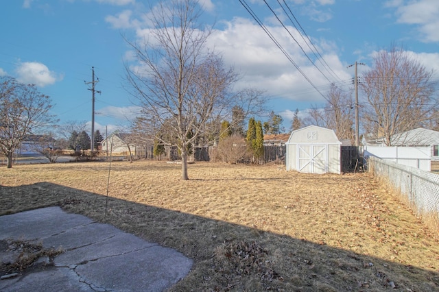 view of yard with an outbuilding, a fenced backyard, and a storage shed