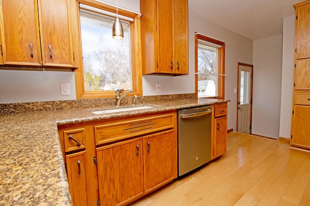 kitchen with a sink, a wealth of natural light, light wood-style flooring, and dishwasher