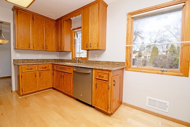 kitchen featuring light wood-type flooring, visible vents, brown cabinets, and stainless steel dishwasher