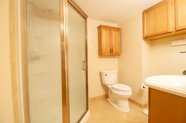 bathroom featuring tile patterned flooring, toilet, vanity, baseboards, and a shower stall