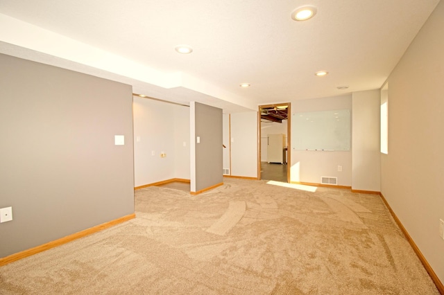 spare room with recessed lighting, light colored carpet, visible vents, and baseboards