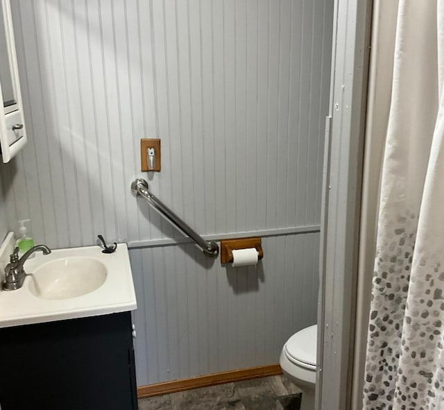 full bath featuring toilet, wood walls, vanity, and a shower with curtain