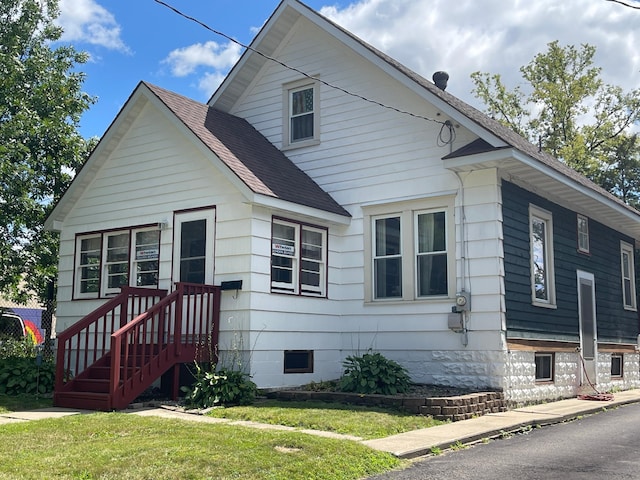 view of front of property featuring a front yard, crawl space, and roof with shingles