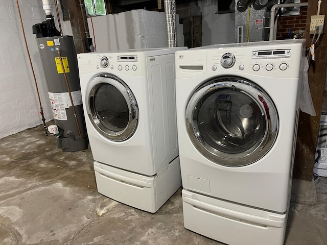 clothes washing area with concrete block wall, laundry area, water heater, and independent washer and dryer