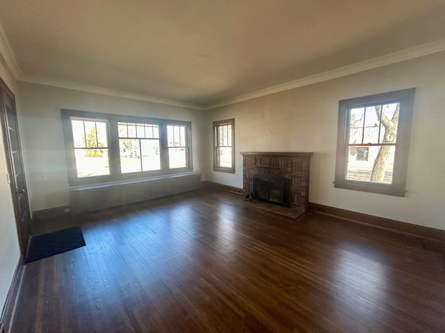 unfurnished living room featuring ornamental molding, a brick fireplace, dark wood finished floors, and baseboards