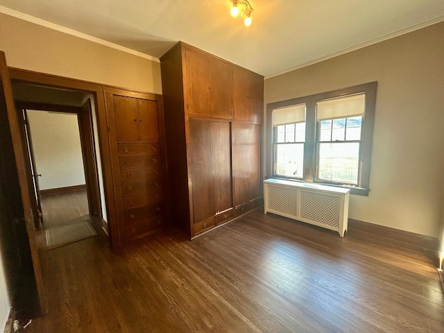 unfurnished bedroom with ornamental molding, dark wood-style flooring, a closet, and radiator heating unit