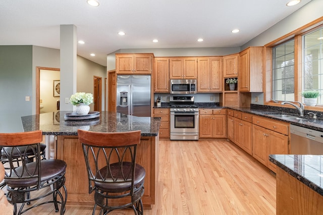 kitchen featuring stainless steel appliances, light wood-type flooring, a sink, and recessed lighting