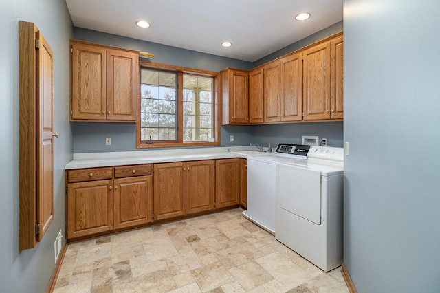 laundry area with recessed lighting, cabinet space, a sink, separate washer and dryer, and baseboards