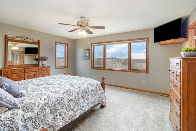 bedroom with ceiling fan, baseboards, and light colored carpet