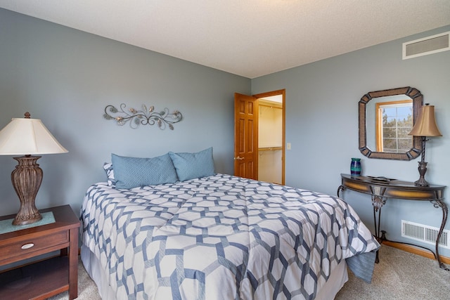 bedroom featuring visible vents, a textured ceiling, and carpet flooring