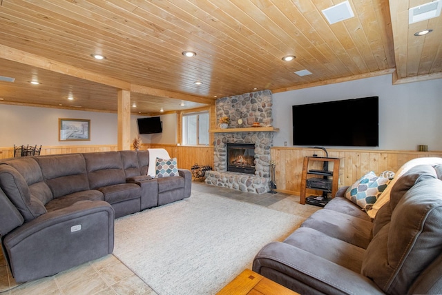 living room featuring visible vents, wooden ceiling, a wainscoted wall, a stone fireplace, and recessed lighting