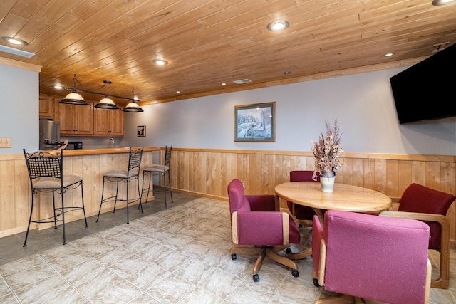 dining space featuring recessed lighting, wood walls, wood ceiling, and wainscoting