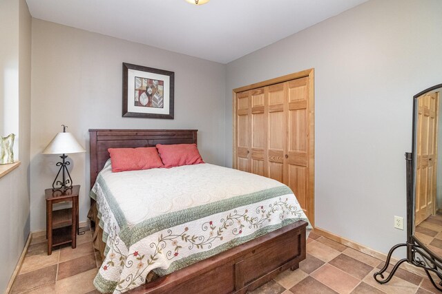 bedroom featuring arched walkways, a closet, and baseboards