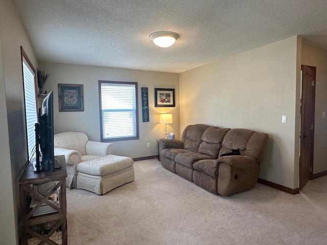 living room with light colored carpet, baseboards, and a textured ceiling