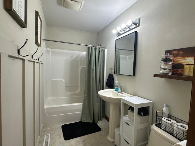 bathroom featuring toilet, shower / bathtub combination with curtain, and visible vents