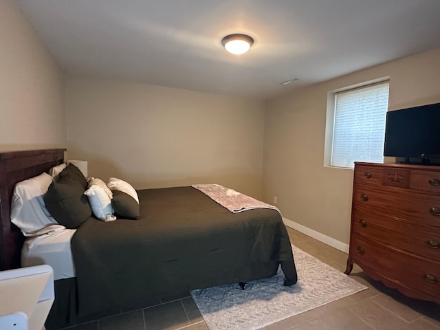 tiled bedroom featuring baseboards