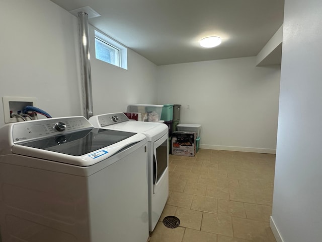 clothes washing area featuring laundry area, independent washer and dryer, and baseboards