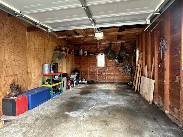 garage with wood walls and a garage door opener