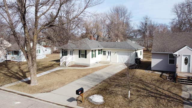 ranch-style home featuring a garage, roof with shingles, concrete driveway, and a chimney