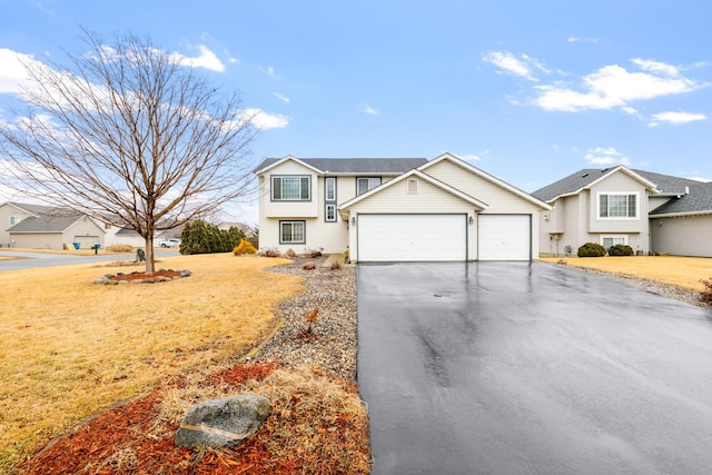 view of front of property with aphalt driveway, an attached garage, and a front yard