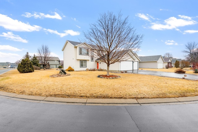 view of front facade with driveway, a garage, and a front yard