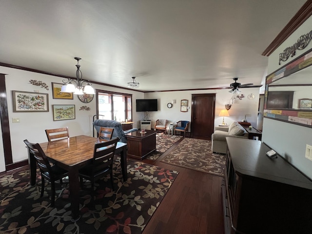 dining room with ornamental molding, dark wood-type flooring, and ceiling fan with notable chandelier