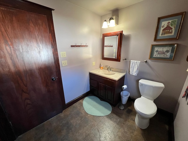 half bathroom with toilet, baseboards, and vanity