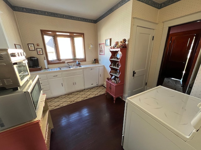 kitchen featuring wallpapered walls, washer / dryer, dishwasher, light wood-style flooring, and white cabinetry