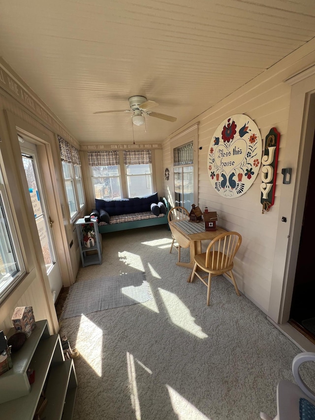 sunroom / solarium featuring a ceiling fan