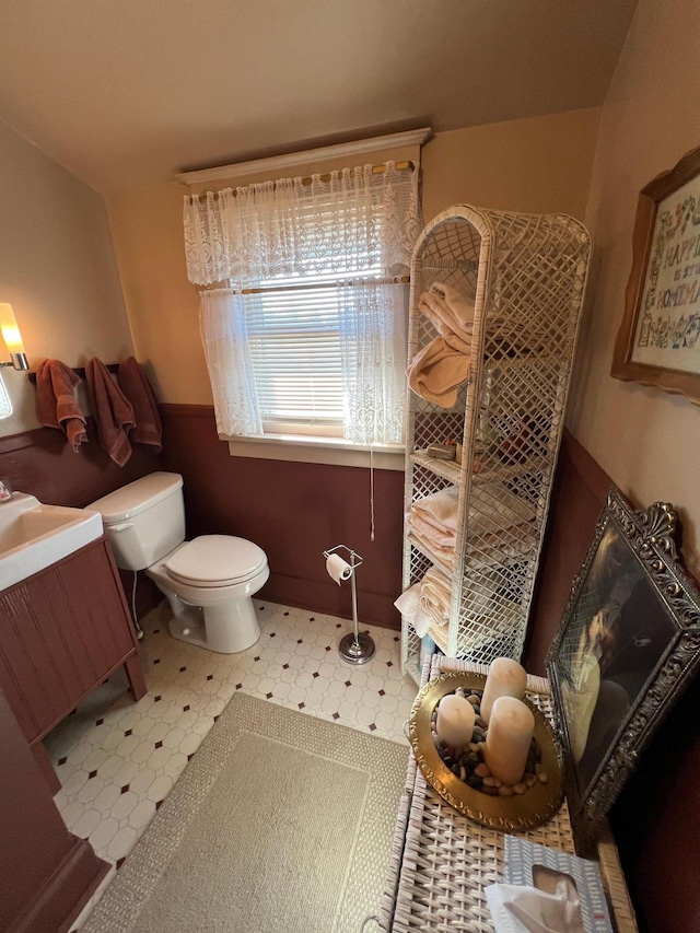 full bathroom featuring a tile shower, vanity, toilet, and tile patterned floors