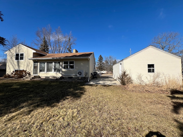 back of property featuring a chimney and a yard