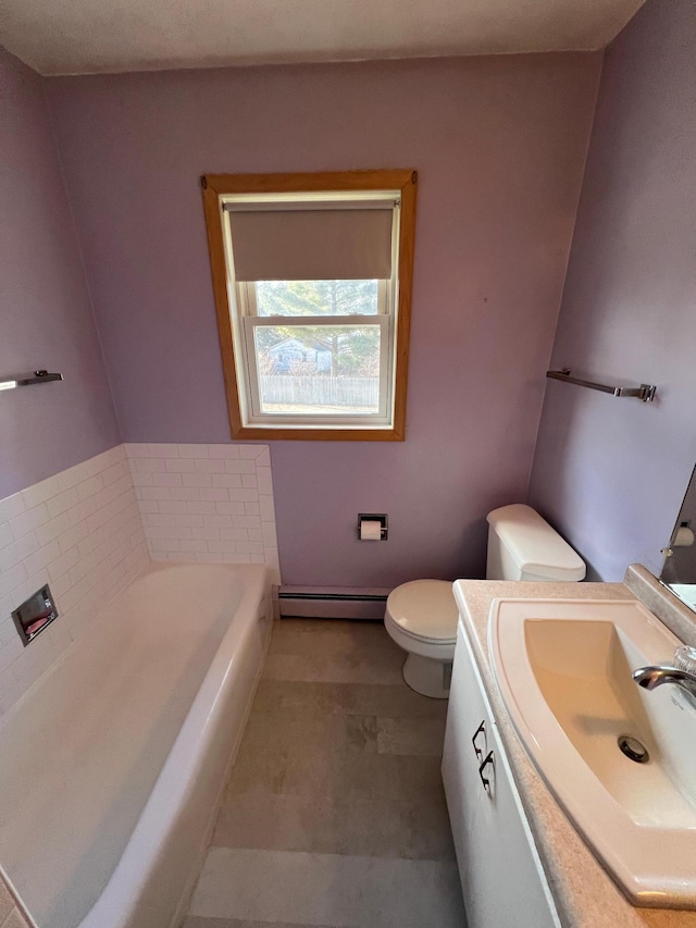 bathroom featuring a tub to relax in, baseboard heating, vanity, and toilet