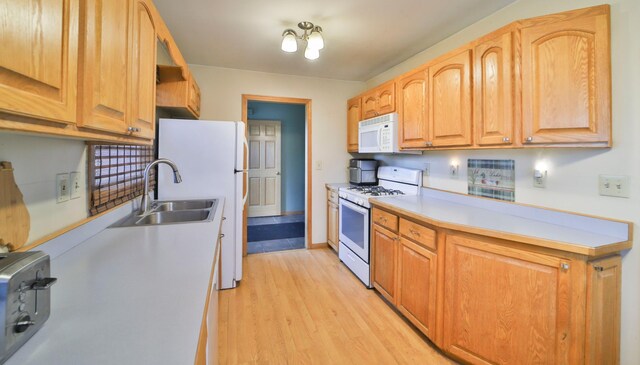 61279 US Highway 169, Hill City, MN 55748 - kitchen with light countertops, a sink, light wood-style floors, and white appliances