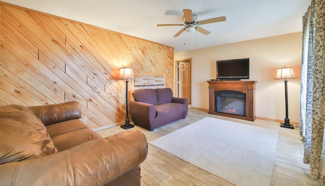 61279 US Highway 169, Hill City, MN 55748 - living area with wood walls, baseboards, wood finished floors, a ceiling fan, and a glass covered fireplace
