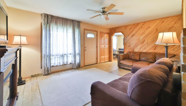 61279 US Highway 169, Hill City, MN 55748 - living room with a fireplace with raised hearth, arched walkways, visible vents, ceiling fan, and wood finished floors